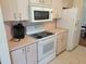 Kitchen featuring an oven, microwave, refrigerator, and cabinetry for storage at 10269 Sw 63Rd Ave, Ocala, FL 34476