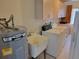 A practical laundry room featuring a utility sink, washer, dryer, and ample cabinet space at 10269 Sw 63Rd Ave, Ocala, FL 34476