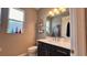 Well-lit half bath featuring a modern vanity, a white countertop, and a decorative mirror at 10287 Sw 96Th Ln, Ocala, FL 34481