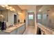 Bathroom featuring double sink vanity with granite countertop, glass shower, warm lighting for a spa-like experience at 10287 Sw 96Th Ln, Ocala, FL 34481