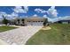 Inviting exterior of the home featuring a brick driveway and a two-car garage at 10287 Sw 96Th Ln, Ocala, FL 34481