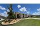 Beautifully landscaped front yard featuring a stone retaining wall and manicured lawn at 10287 Sw 96Th Ln, Ocala, FL 34481