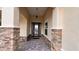 Covered front porch with elegant stone pillars and a decorative patterned front door at 10287 Sw 96Th Ln, Ocala, FL 34481
