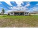 A spacious backyard features a covered patio and lush green grass for outdoor enjoyment at 10553 Sw 98Th Pl, Ocala, FL 34481