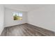 A bedroom has hardwood flooring and a window bringing in natural light and neighborhood views at 10553 Sw 98Th Pl, Ocala, FL 34481