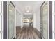Inviting foyer features decorative glass doors, tray ceilings, and wood-look flooring at 10553 Sw 98Th Pl, Ocala, FL 34481