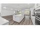 Modern kitchen with oversized island, stainless appliances, and seamless flow into dining and living areas at 10553 Sw 98Th Pl, Ocala, FL 34481