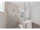 A shower features a partial glass divider, grey tiling, and a built-in shower niche at 10553 Sw 98Th Pl, Ocala, FL 34481