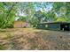 Exterior view of yard with home and shed surrounded by mature trees and landscaping at 1322 Ne 53Rd St, Ocala, FL 34479