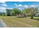 Exterior view of a one-story home on a spacious lawn with mature trees at 1322 Ne 53Rd St, Ocala, FL 34479