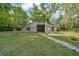 Exterior view of a detached shed with large gated opening and a brick walkway at 1322 Ne 53Rd St, Ocala, FL 34479
