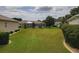 Spacious backyard with manicured lawn and views of neighboring homes and mature trees in the community at 13863 Se 85Th Cir, Summerfield, FL 34491