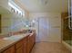 Bathroom with double vanity, tile flooring, neutral walls, and a glass-enclosed shower at 13863 Se 85Th Cir, Summerfield, FL 34491