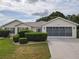 Charming single-story home with a well-manicured lawn and a two-car garage, enhanced by lush landscaping at 13863 Se 85Th Cir, Summerfield, FL 34491