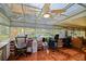Bright sunroom with ceiling fan, tile floors, and large windows offering scenic views at 13863 Se 85Th Cir, Summerfield, FL 34491