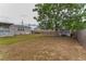 Large, mostly dry backyard with wooden fence, shed, and large shady tree at 14276 Se 61St Ave, Summerfield, FL 34491