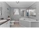Bathroom with a tub, toilet, and double sink vanity and neutral flooring at 14276 Se 61St Ave, Summerfield, FL 34491