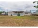 Exterior of home with covered porch and backyard with lawn in need of some care at 14276 Se 61St Ave, Summerfield, FL 34491