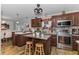 A cozy kitchen with stainless steel appliances, an island, and access to the dining room at 14276 Se 61St Ave, Summerfield, FL 34491