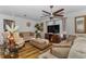 Inviting living room with hardwood floors, ceiling fan, neutral decor, and a large television at 14276 Se 61St Ave, Summerfield, FL 34491