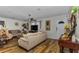 Well-lit living room features hardwood floors, neutral paint, and access to front entry at 14276 Se 61St Ave, Summerfield, FL 34491