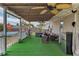 Covered porch with green turf, ceiling fans, and outdoor seating and grill for entertaining at 14276 Se 61St Ave, Summerfield, FL 34491