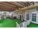 Covered porch with swing, green turf, ceiling fans, and seating for outdoor relaxation at 14276 Se 61St Ave, Summerfield, FL 34491