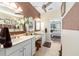Bright bathroom featuring double sinks, large mirror, and a view of the main bedroom at 1429 Sw 160Th Ln, Ocala, FL 34473