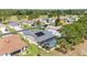 An aerial view shows the house with a pool, solar panels and the neighborhood at 15119 Sw 14Th Avenue Rd, Ocala, FL 34473