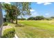 A lush green backyard overlooking a golf course, with mature trees adding privacy at 15119 Sw 14Th Avenue Rd, Ocala, FL 34473