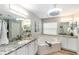 Bright bathroom featuring a soaking tub, dual sinks with granite countertops, and modern fixtures at 15119 Sw 14Th Avenue Rd, Ocala, FL 34473