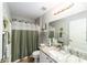 Bathroom with a shower-tub combo, decorative shower curtain, and granite-topped vanity at 15119 Sw 14Th Avenue Rd, Ocala, FL 34473