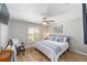 Cozy bedroom with hardwood floors, a ceiling fan, and natural light from the window at 15119 Sw 14Th Avenue Rd, Ocala, FL 34473