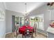 Cozy dining area adjacent to kitchen, with a chandelier, sliding glass doors, and a bright, inviting atmosphere at 15119 Sw 14Th Avenue Rd, Ocala, FL 34473
