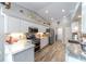 Well-lit kitchen featuring stainless appliances, white cabinetry, and tiled backsplash, connecting to utility room at 15119 Sw 14Th Avenue Rd, Ocala, FL 34473