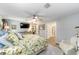 Spacious main bedroom with a floral-themed comforter, TV, ceiling fan, and access to the en-suite bathroom at 15119 Sw 14Th Avenue Rd, Ocala, FL 34473