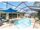 Inviting screened-in pool area with lounge chairs, manicured landscaping, and a clear blue pool at 15119 Sw 14Th Avenue Rd, Ocala, FL 34473