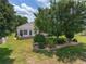 Beautifully landscaped backyard with a well-kept lawn, mature trees, and a cozy outdoor patio area at 1748 Sw 157Th Place Rd, Ocala, FL 34473
