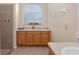 Bathroom featuring a glass block window, vanity with countertop, and tiled shower, offering a spa-like experience at 1748 Sw 157Th Place Rd, Ocala, FL 34473