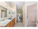 Hallway view to a bathroom showcasing dual sinks, a window providing natural light, and a clean, functional layout at 1748 Sw 157Th Place Rd, Ocala, FL 34473