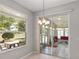 Cozy dining area with stylish chandelier and sliding glass doors leading to a sunroom with outdoor views at 1748 Sw 157Th Place Rd, Ocala, FL 34473