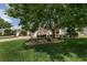 Landscaped front yard featuring mature shade trees, green grass, and neatly trimmed shrubbery at 1748 Sw 157Th Place Rd, Ocala, FL 34473