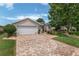 Inviting single-story home featuring a manicured lawn, brick driveway, and well-maintained landscaping at 1748 Sw 157Th Place Rd, Ocala, FL 34473
