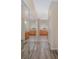 Bright hallway showcasing wood floors, mirrored closet doors, and cabinetry leading to a light-filled bathroom at 1748 Sw 157Th Place Rd, Ocala, FL 34473