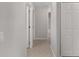 Well-lit hallway featuring neutral walls, tiled flooring, and white doors leading to various rooms at 1748 Sw 157Th Place Rd, Ocala, FL 34473