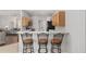 Modern kitchen featuring barstool seating with stainless steel appliances and a view of the living room at 1748 Sw 157Th Place Rd, Ocala, FL 34473