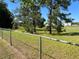 Large backyard with mature trees and a chain-link fence at 21 Pecan Course Cir, Ocala, FL 34472