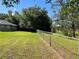 Spacious fenced backyard with lush green grass and mature trees providing shade at 21 Pecan Course Cir, Ocala, FL 34472