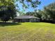 Large backyard with a well-maintained lawn, mature trees, and a view of the house at 21 Pecan Course Cir, Ocala, FL 34472
