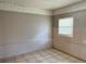 A bedroom with one window, tile floors, and neutral colors at 21 Pecan Course Cir, Ocala, FL 34472